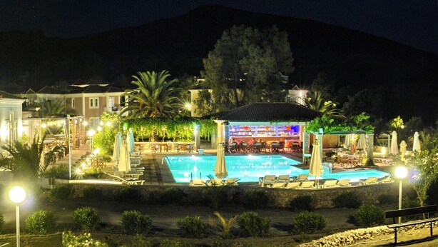 A hotel with a swimming pool, outdoor seating, and a bar area. - Panselinos Hotel (Lesvos)