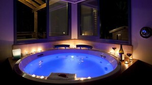 A hot tub with a view of a building through large windows. - Ramot Resort Hotel (Ramot)
