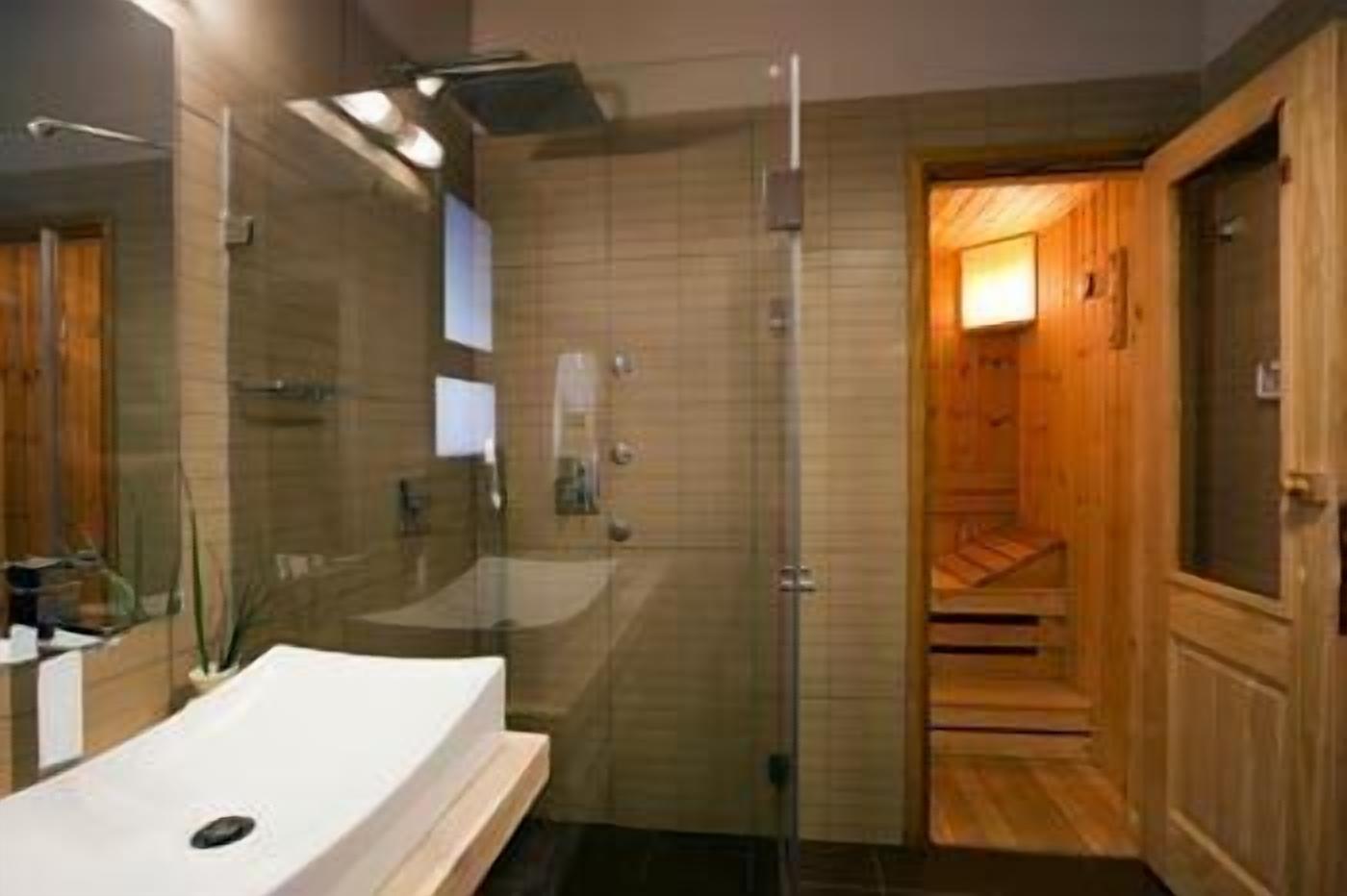 Une salle de bain moderne avec une douche à parois de verre, une porte en bois et un lavabo avec un miroir.