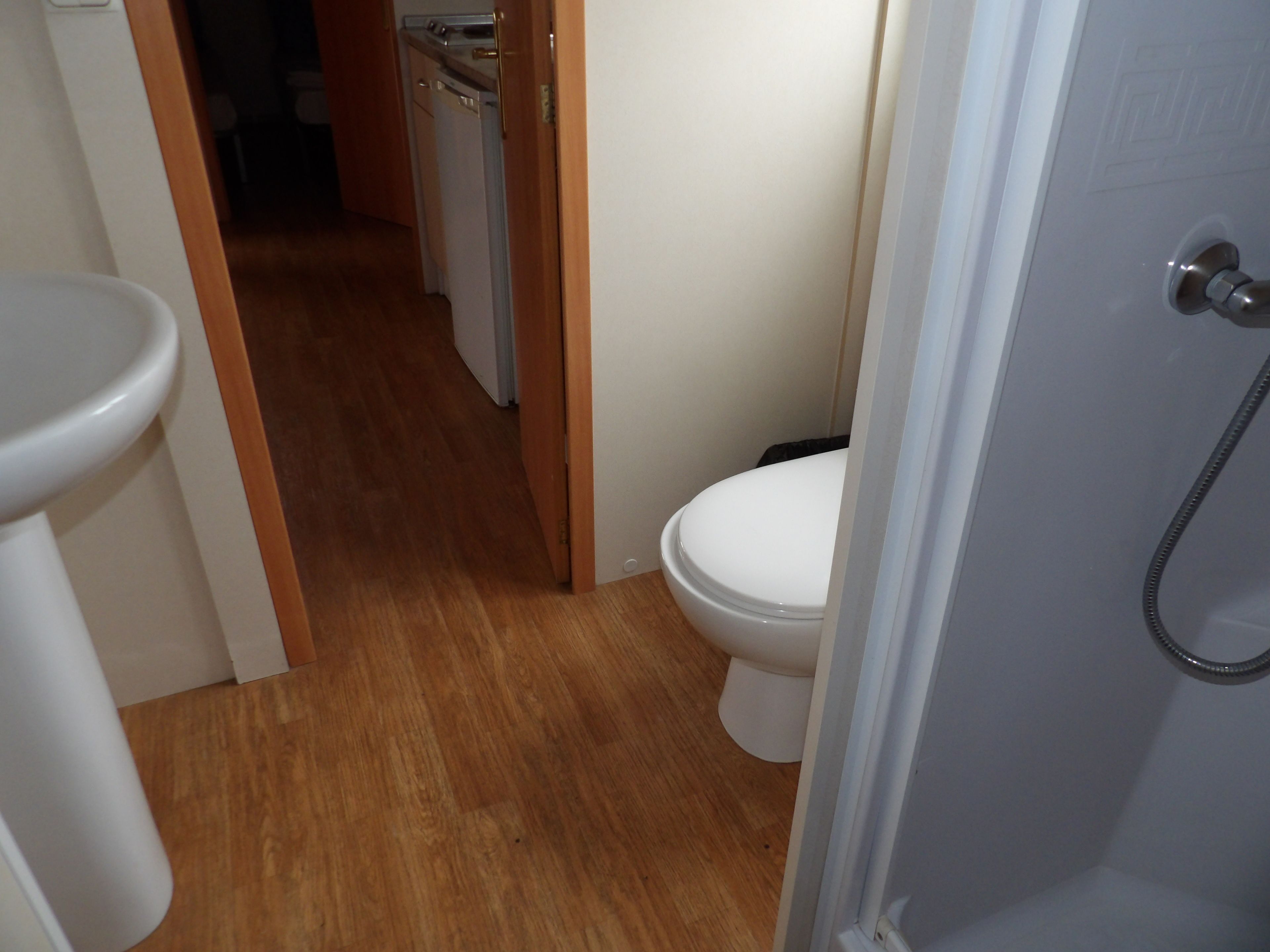 Un baño con inodoro, lavabo y ducha.