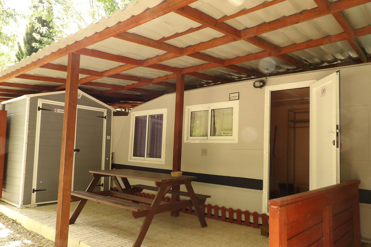 A covered outdoor area with a picnic table, a small building with a window, and a door labeled "PRIVATE".