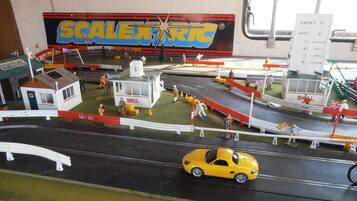 Un modelo detallado de una ciudad costera con edificios en miniatura, vehículos y un muelle.