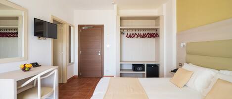 A hotel room with a bed, a desk, a TV, a wardrobe, and a bathroom.