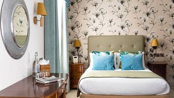 Une chambre à coucher comprenant un lit, deux tables de chevet, un miroir et une commode.