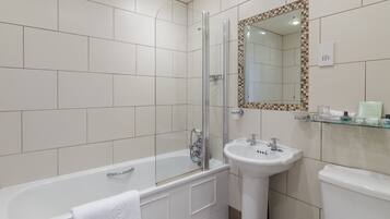 A bathroom with a bathtub, a glass-enclosed shower, a sink, and a toilet.