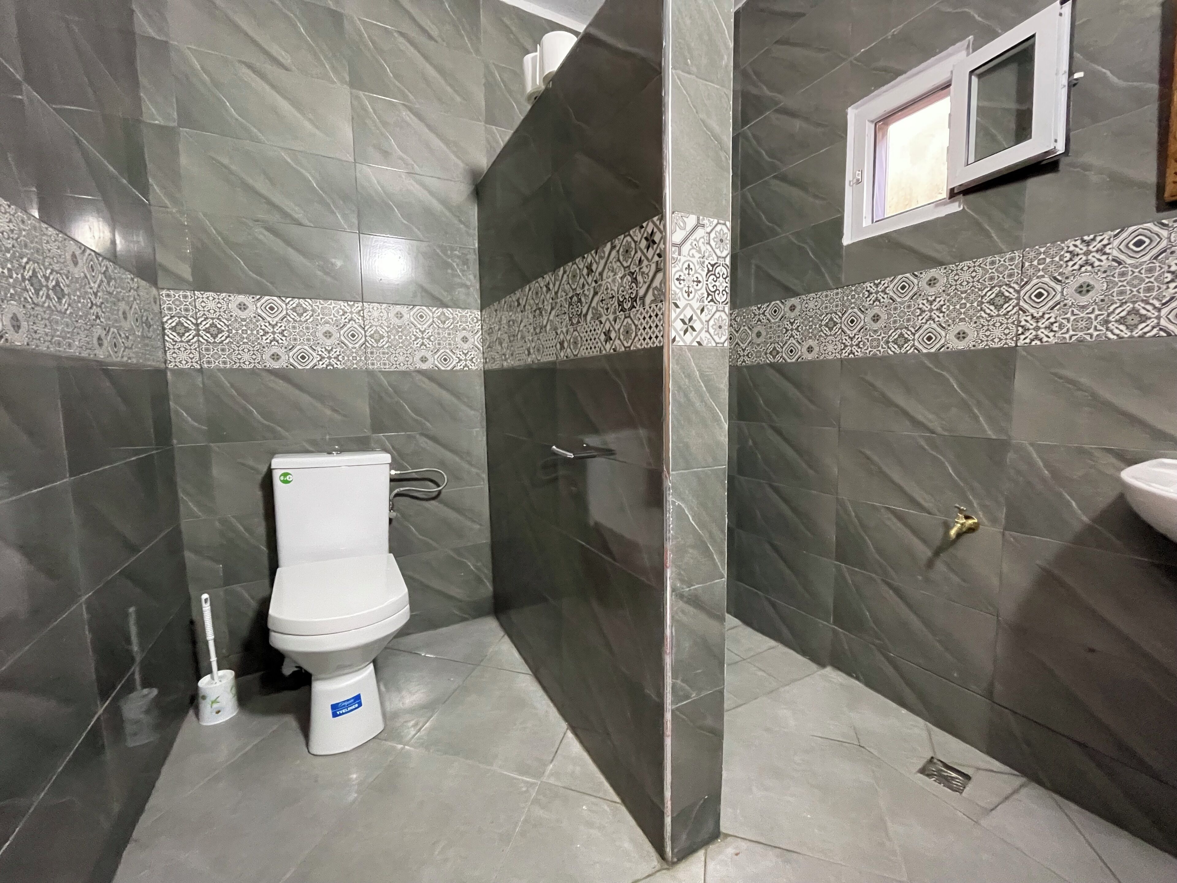 Une salle de bain avec des toilettes, une douche et un lavabo.