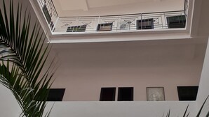 A multi-level interior with a skylight, white walls, and a view of the sky. - Riad Sidi Magdoul (Essaouira)