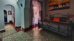 A room with a bed, patterned floor, and a painting of elephants. - Riad Sidi Magdoul (Essaouira)