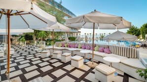 A rooftop pool area with lounge seating, umbrellas, and a checkered floor. - Zornitza Sands SPA (Elenite)
