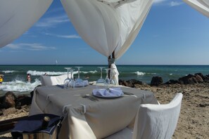 A beachside dining setup with a table set for two, overlooking the ocean. - Zornitza Sands SPA (Elenite)