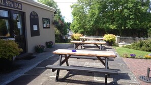 An outdoor seating area with picnic tables and a spa bar.