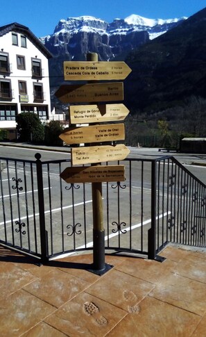 A directional signpost with multiple wooden arrows pointing towards various destinations and their travel times.