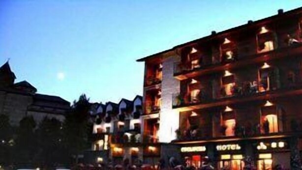Un hôtel à étages multiples, doté de balcons et présentant un style architectural traditionnel, avec des fenêtres apparentes et une enseigne indiquant qu’il s’agit d’un hôtel.