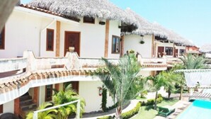 A resort with multiple buildings, each with a thatched roof and a pool area. - Hotel Il Nuraghe (Aracati)