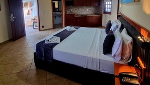 A hotel room with a bed, a desk, a painting, and a view of the outside. - Hotel Il Nuraghe (Aracati)