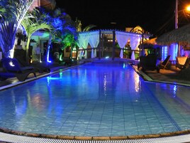 Una piscina al aire libre, sillones reclinables de piscina