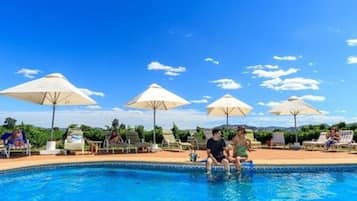 Een buitenzwembad, parasols voor strand/zwembad