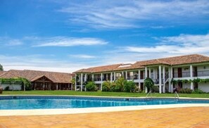 Piscina externa, guarda-sóis, espreguiçadeiras