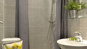 Une salle de bain moderne équipée d’une douche, de toilettes et d’un lavabo.