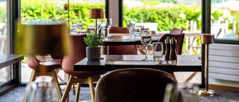 A restaurant table set with wine glasses, a salt and pepper shaker, and a small plant.