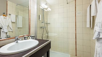Une salle de bain avec un lavabo, un miroir et une douche.