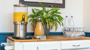 A bar area with a beverage dispenser, a potted plant, and a glassware rack.