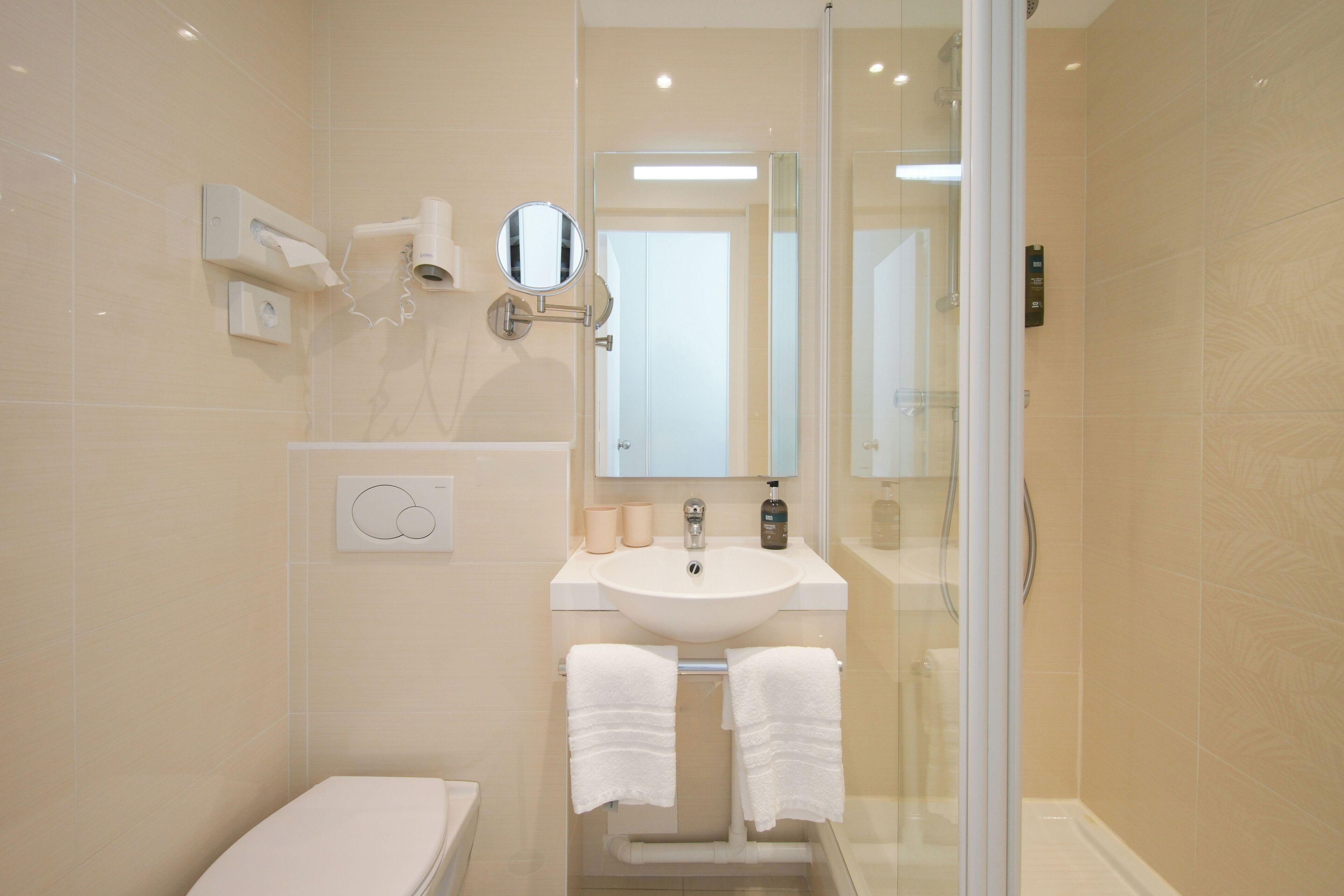 A modern bathroom with a toilet, sink, and shower.