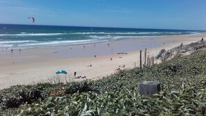 A beach with a wooden fence, a sandy shore, and a clear sky. - Hotel La Forestière (Biscarrosse)