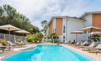 Una piscina al aire libre de temporada, sombrillas