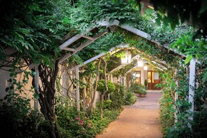 A pathway flanked by lush greenery and a wooden pergola structure. - Last Word Franschhoek (Franschhoek)