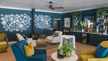 A living room with a blue and yellow sofa set, a coffee table, and a wall decorated with blue and white plates.