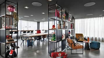 A modern office space with a desk, chairs, a bookshelf, and a red toy car.