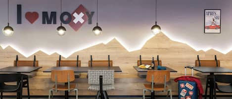 Un restaurante con un diseño de pared al estilo de montaña, mesas y sillas de madera, y un tablero de menú a la vista.