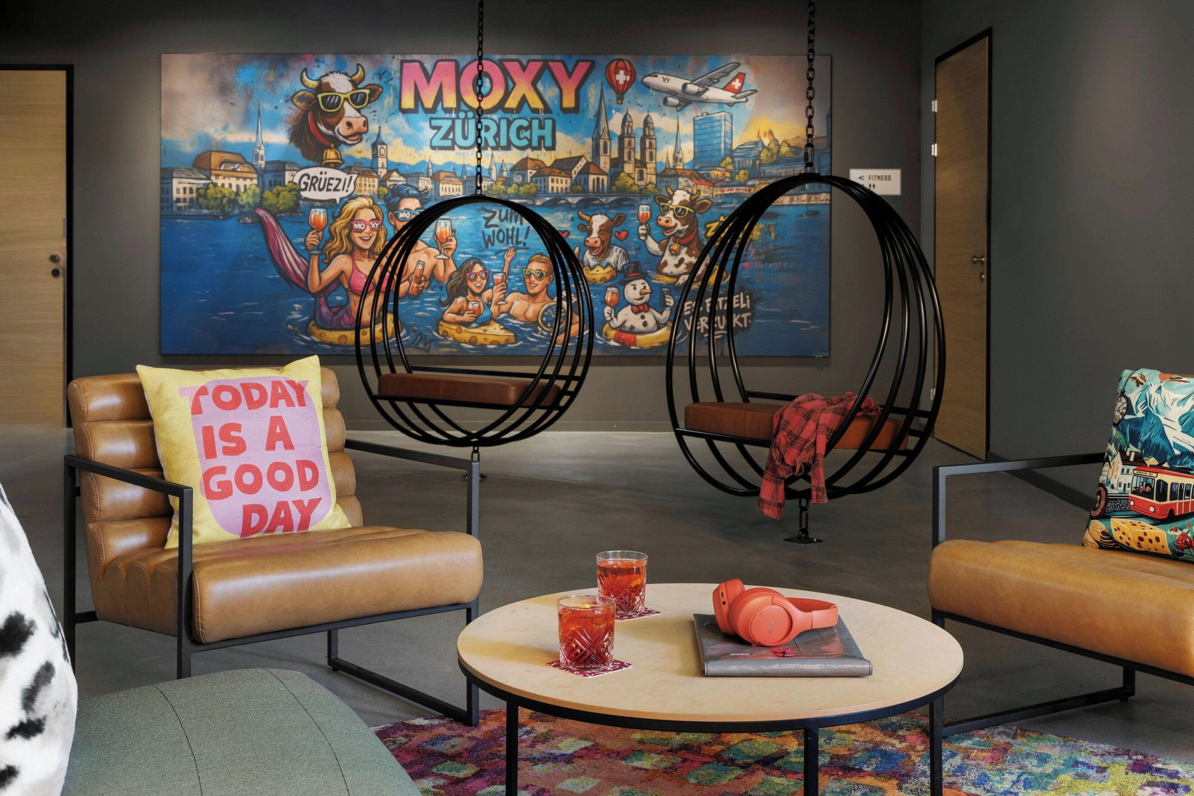 Un espace de détente moderne avec des canapés en cuir, une table basse ronde et un tapis aux couleurs vives.