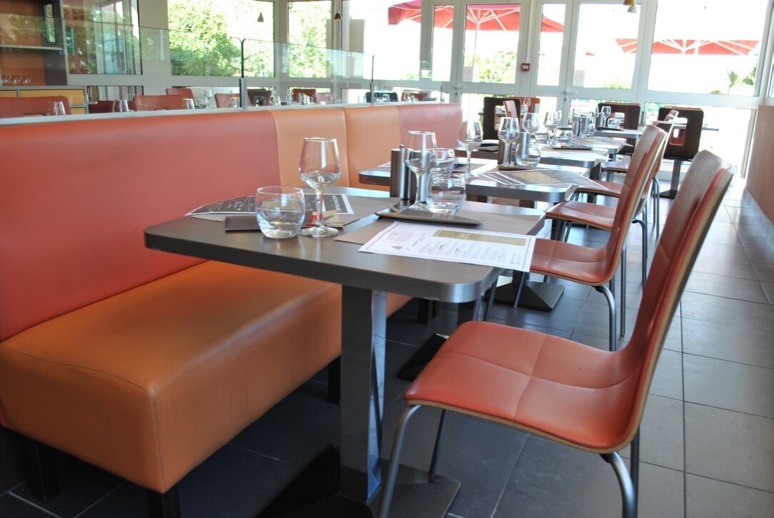 A restaurant with booths and tables, some with menus and glasses.