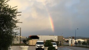 A parking lot with a white car, a rainbow in the sky, and a building in the background. - ibis Loriol Le Pouzin (Le Pouzin)