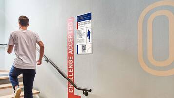 A person descending a staircase with a red banner reading 'CHALLENGE ACCEPTED!' on the wall.