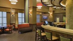 A hotel lobby with a bar area, seating arrangements, and a television screen. - Hyatt Place Columbus/OSU (Columbus)