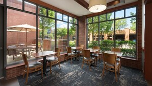 A restaurant with large windows, brick walls, and outdoor seating. - Hyatt Place Columbus/OSU (Columbus)