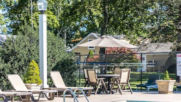 En säsongsöppen utomhuspool, parasoller och solstolar
