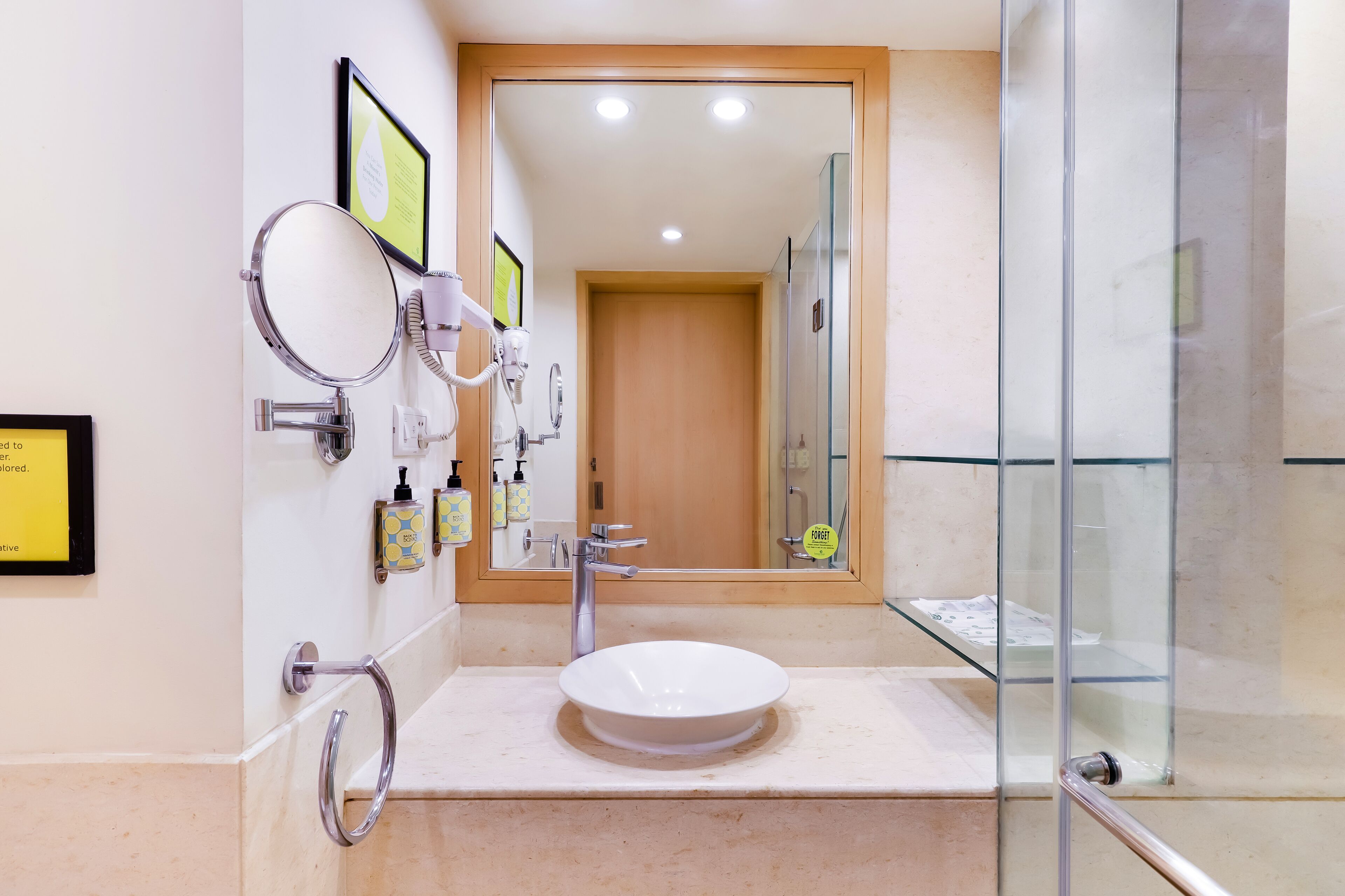 Une salle de bain moderne avec un miroir rond, un lavabo et une cabine de douche en verre.