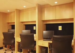 A row of office cubicles with individual desks, chairs, and computers.