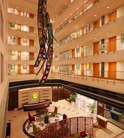 A multi-level hotel lobby with a central reception desk, multiple floors, and a decorative hanging sculpture.