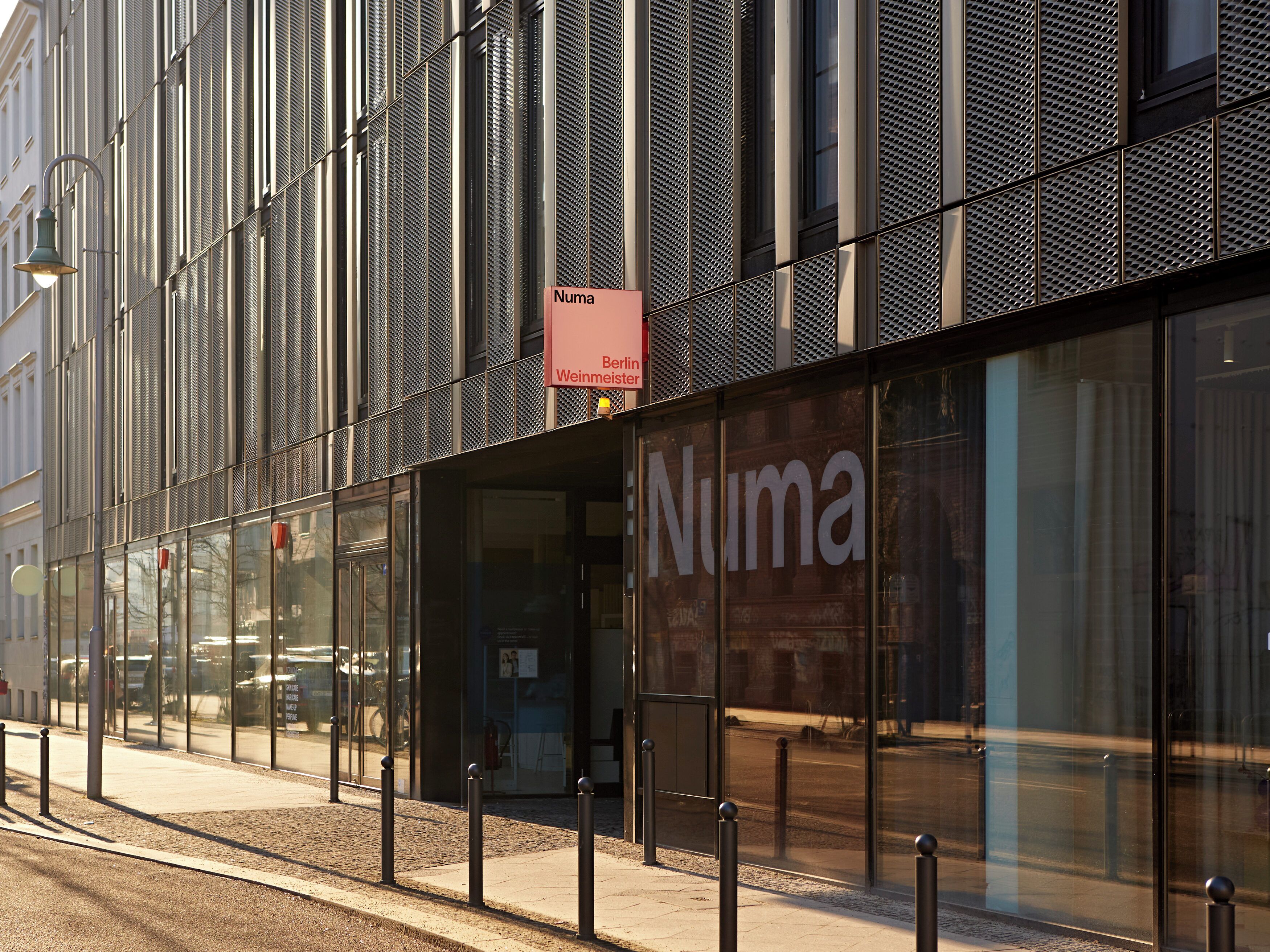 A modern building facade with large glass windows and a prominent 'Numa' sign.