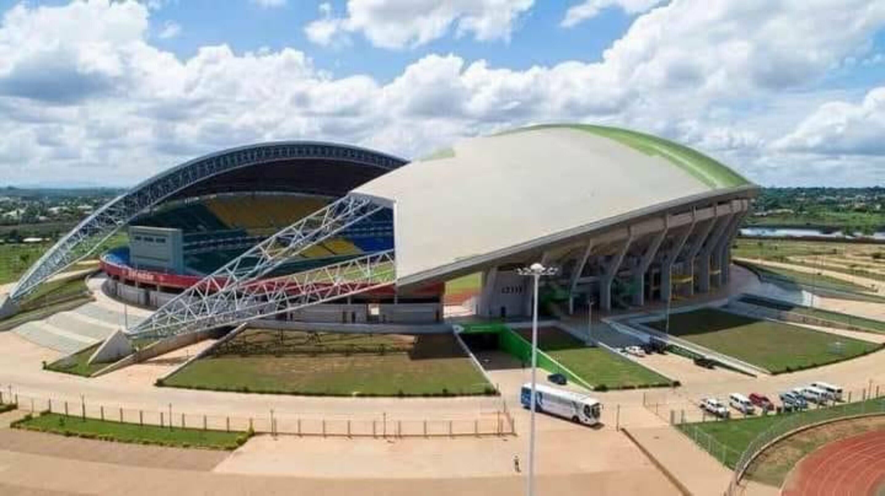 Un stade doté d’un grand toit incurvé et d’une structure arquée centrale.