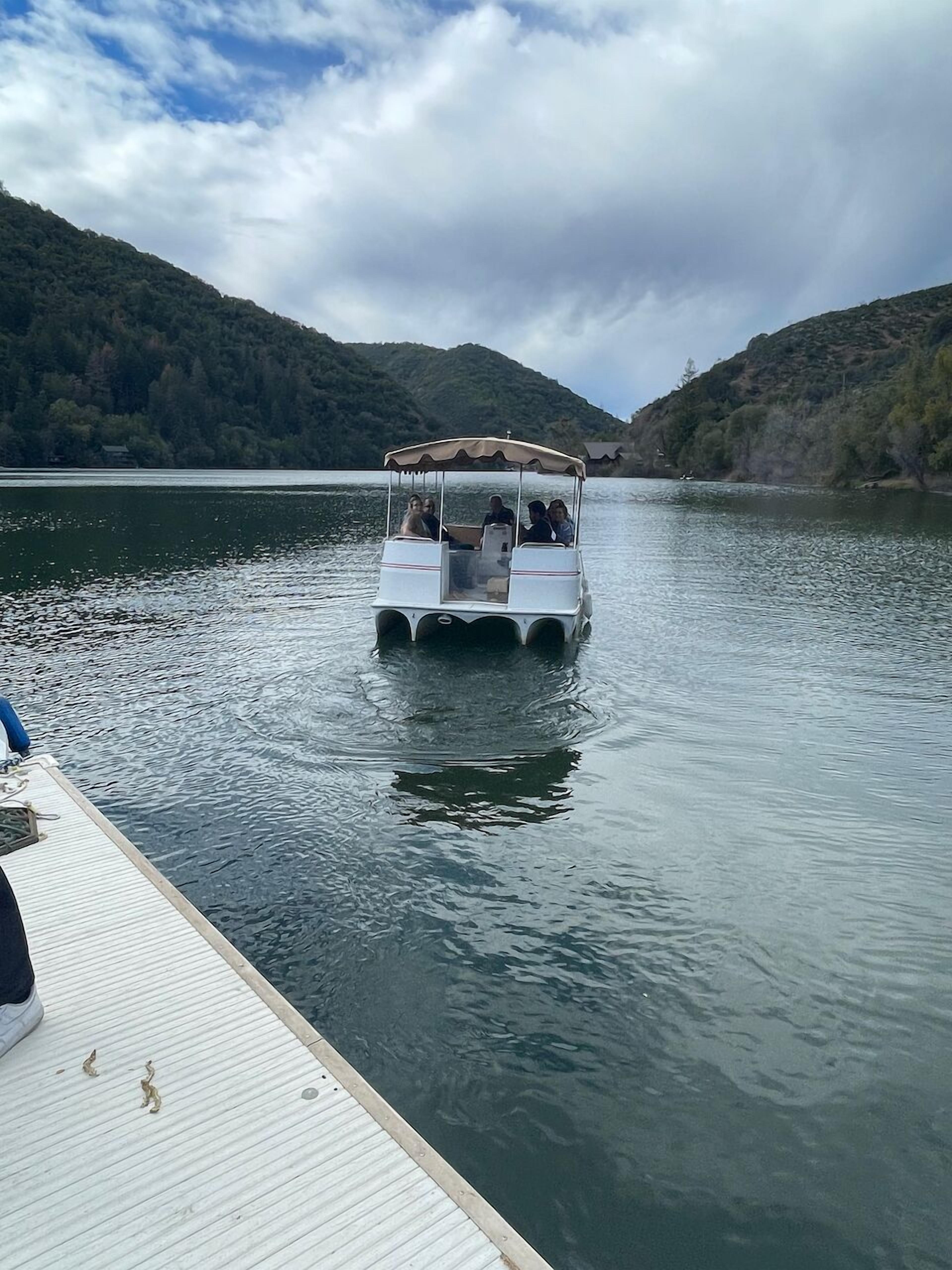 A boat on calm water with a dock on the left.