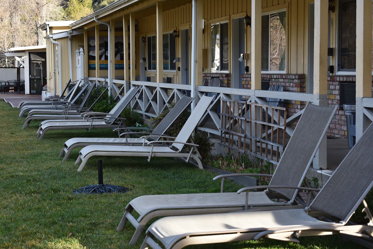 Une rangée de chaises longues est alignée à l’extérieur d’un bâtiment doté d’un porche.