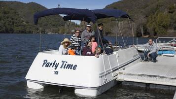 Katettu kannella varustettu vene, jonka kylkeen oli maalattu teksti ”Party Time”, oli ankkuroitu laituriin.