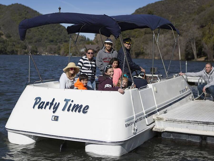 Katettu kannella varustettu vene, jonka kylkeen oli maalattu teksti ”Party Time”, oli ankkuroitu laituriin.