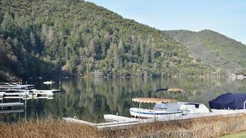 Um lago tranquilo com barcos atracados, cercado por colinas arborizadas.
